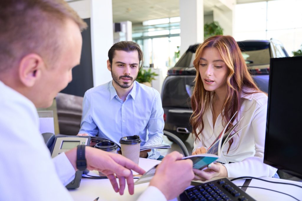 Automotive consultant advising his customers on vehicle purchase